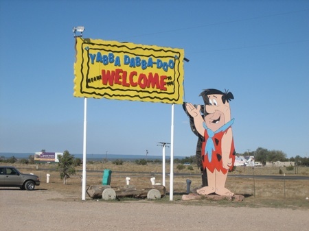 Fred welcomes you to an aesthetic experience welcome sign to Flinstone land