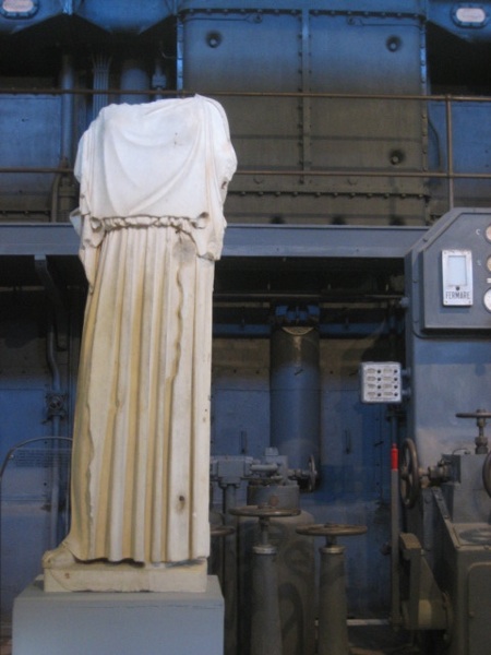 headless figure in front of a turbine