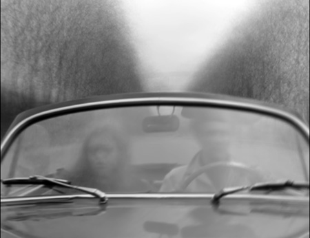two people driving a car in a winter landscape