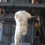 Roman torso in front of a machine